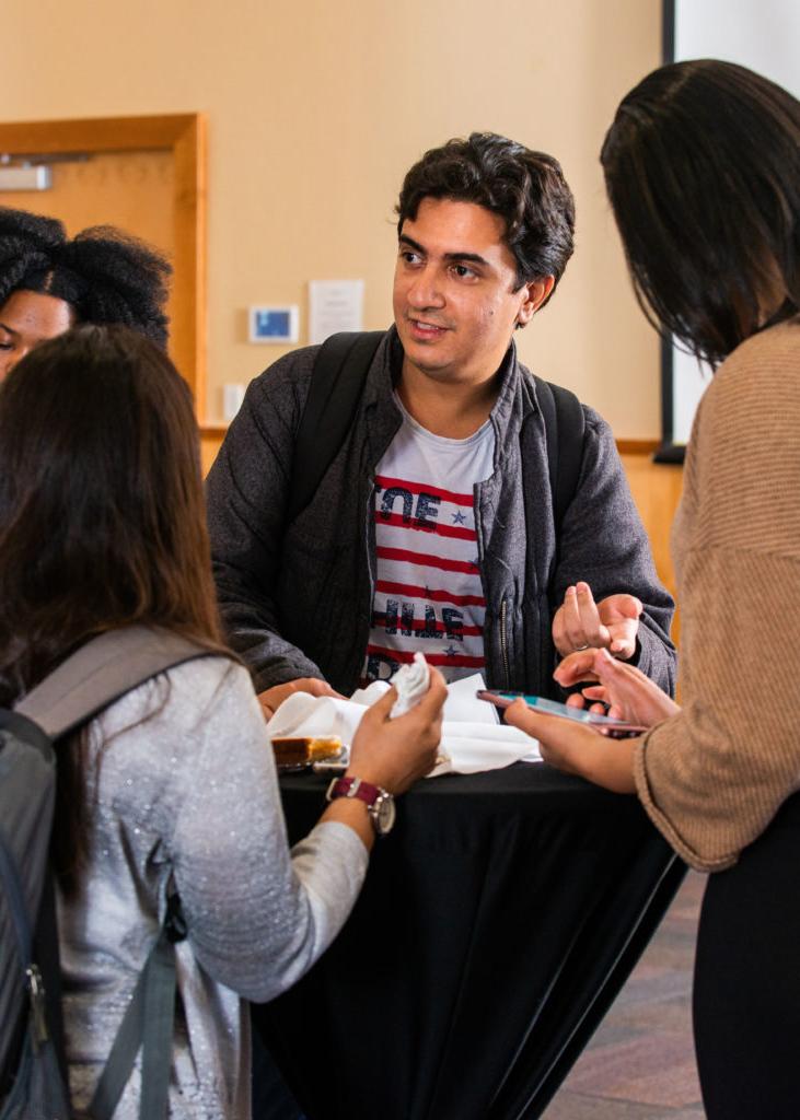 A group of students talking around a table.